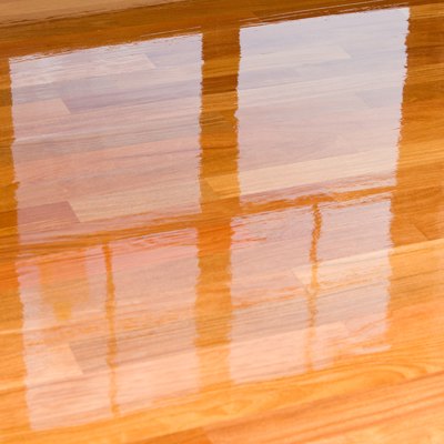 Wet polyurethane on new hardwood floor with window reflection.