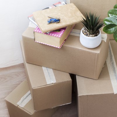 full boxes of things with indoor flowers and keys to a new house, moving to another housing, top view