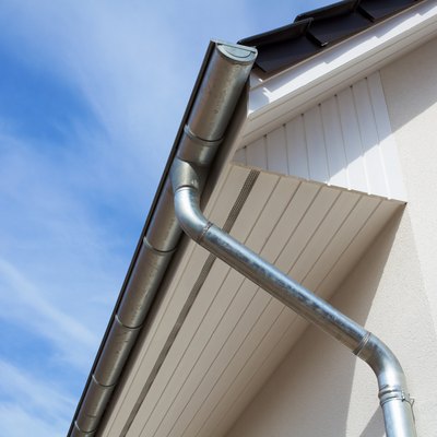 Architectural close-up of a metal rain gutter with downspout