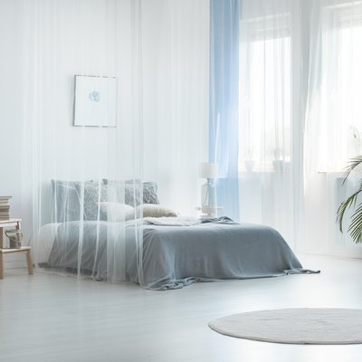 Bright, airy blue and white bedroom with sheer curtains.
