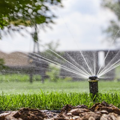 automatic sprinkler system watering the lawn on a background of green grass
