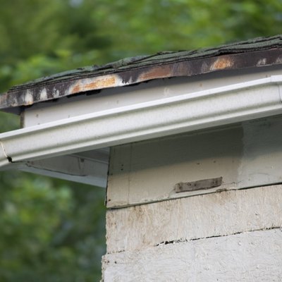 Damaged and old roofing shingles and gutter system on a house