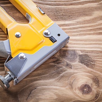 Staple gun on wooden board directly above construction concept