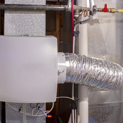 A home humidifier attached to the return duct with a bypass connection to the supply hot air duct.