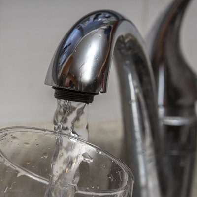 Glass at water tap and filling water with lead contamination