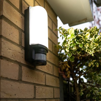 Exterior PIR LED security light seen glowing following body motion detection via its Infra Red sensor.