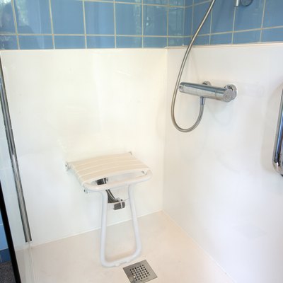 Handicapped disabled shower chair for elderly or disabled people with handle bar in senior home, safety concept