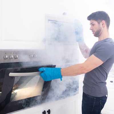Man Opening Oven Filled With Smoke