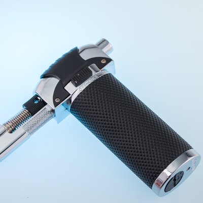 Kitchen mini blow torch with black handle.