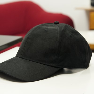 Black hat with visor on a white table.