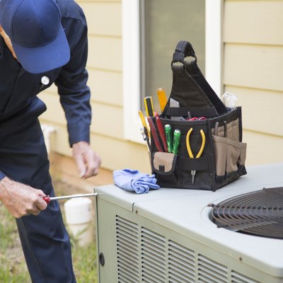Technician services outside AC unit and generator.