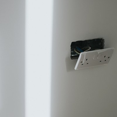 Plug Socket hanging off a freshly plastered wall in a new Build