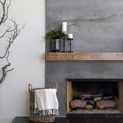 Modern gray textured fireplace with basket and tree branch