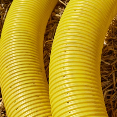 Close up picture of perforated yellow land drainage pipe.