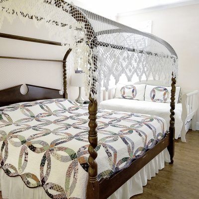 Canopy bed with antique quilt.