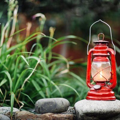 Red kerosene lamp isolated on garden background