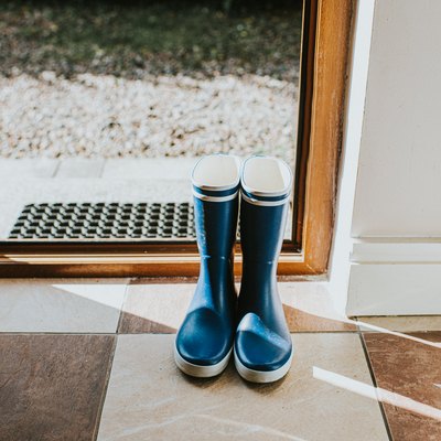 Blue Welly boots sitting by an open back door.