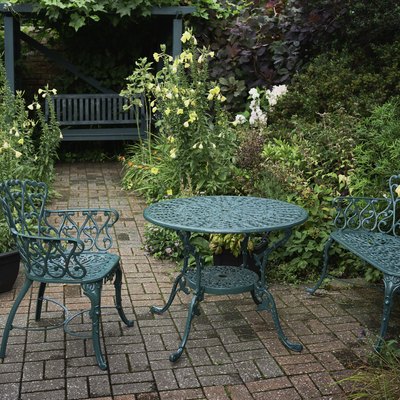 Painted wrought iron table and chairs in garden..