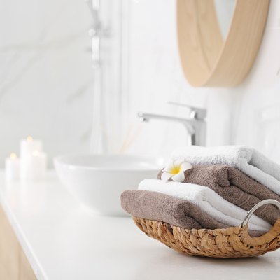 Basket with clean towels on counter in bathroom. Space for text