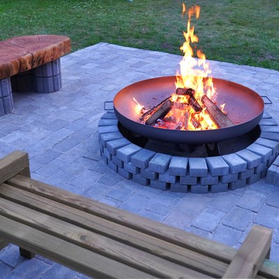 Iron firepit and burning fire on patio.