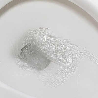 Motion blur of flushing water in toilet bowl. Plumbing, home repair and water conservation concept.
