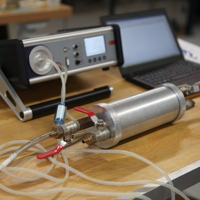 Radon gas radiation detectors testing. Dosimetrist holding a portable gamma radiation dosimeter set on a long tube with sample probe .