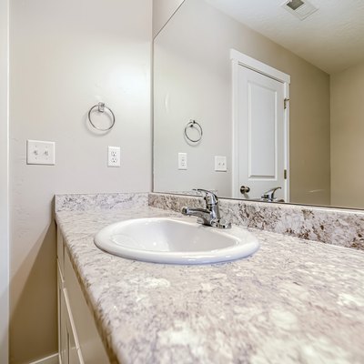 Top mount sink with stainless steel faucet on bathroom marble countertop