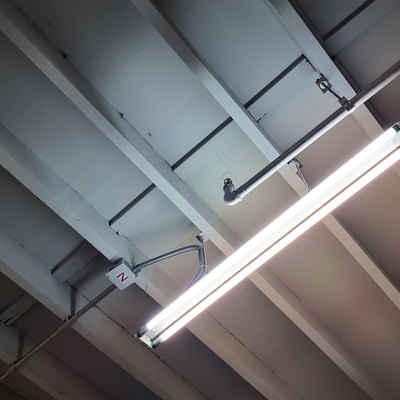 unfinished ceiling showing beam structure, electrical system, piping system and fluorescent lighting. industrial or loft style of interior decoration. bare ceiling for construction concept.