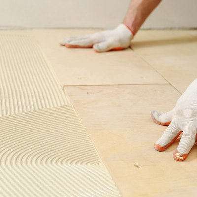 Laying plywood on a floor.
