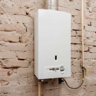 Closeup of gas water heater on a brick wall. Gas boiler in boiler room for hot water