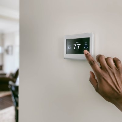 Woman adjusting touchscreen thermostat settings