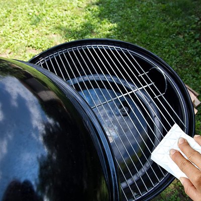 Cleaning the grill grate with a Mr. Clean Magic Eraser cleaning pad.