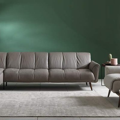 A gray Natuzzi couch in a living room