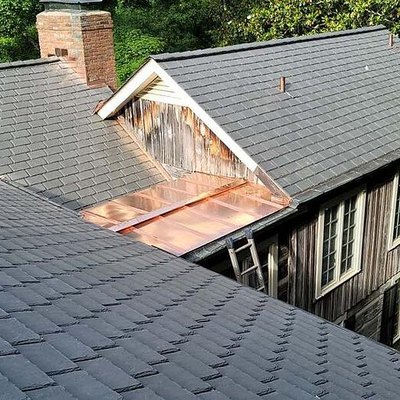 A synthetic slate roof on an old wooden farmhouse