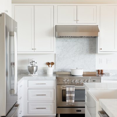 contemporary white kitchen with small area of marble backsplash above the oven