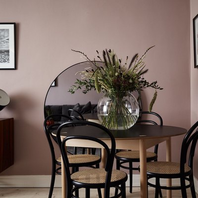 mauve dining area wirh black accents via picture frames, dining chairs and lighting