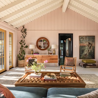 A-frame ceiling living room with earthy furniture, eclectic decor, and yellow French doors.