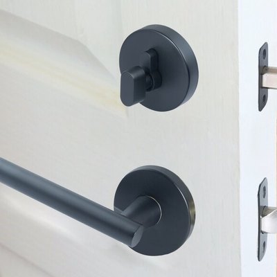 Black metal door handle and matching single cylinder deadbolt lock on a partially open white door