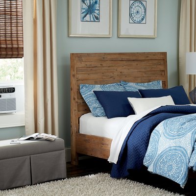 White window air conditioner in blue and beige bedroom