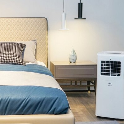 Portable air conditioner in blue, white, and beige bedroom