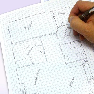 Sketching a  house plan on graph paper.