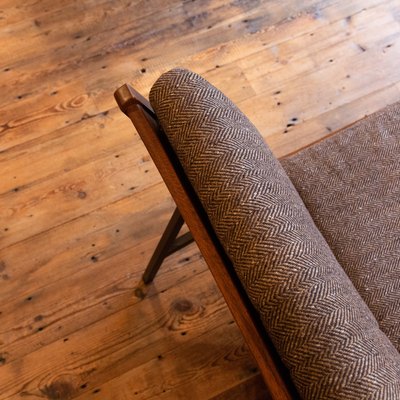 a futon couch with a herringbone pattern on a rustic wood floor