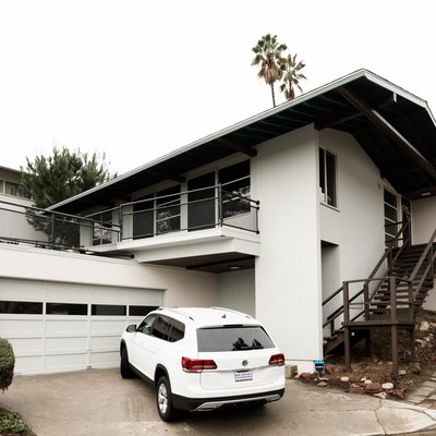White home with large overhanging eaves with white car in driveway
