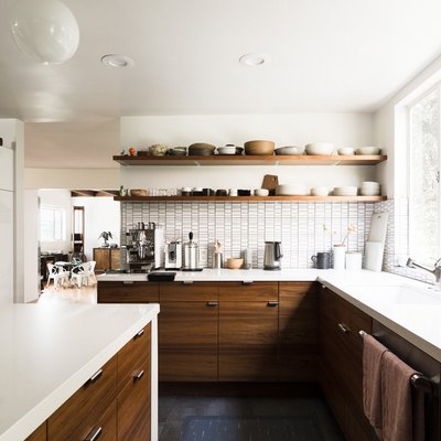 Kitchen with long white counters and wooden cabinets with open shelving