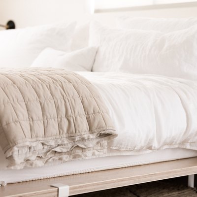 a platform bed made from birch plywood panels with white bedding