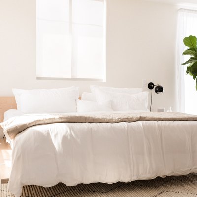 a platform bed made from birch plywood panels with white bedding