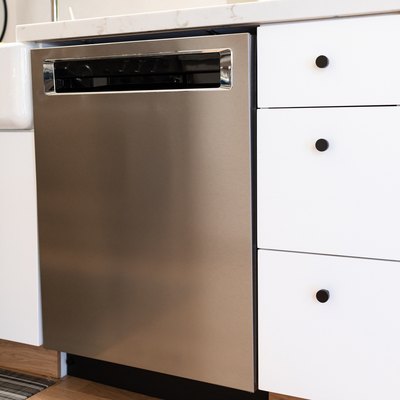 white kitchen cabinets with black hardware and stainless steel dishwasher