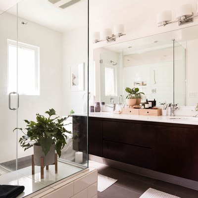 modern double sink bathroom with glass shower and dark wooden vanity