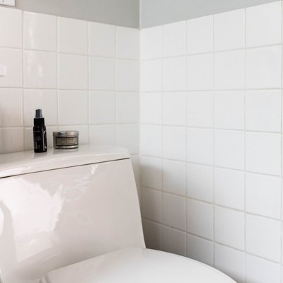 white bathroom tile with toilet