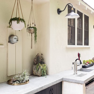 outdoor kitchen with hanging plants and stone countertop